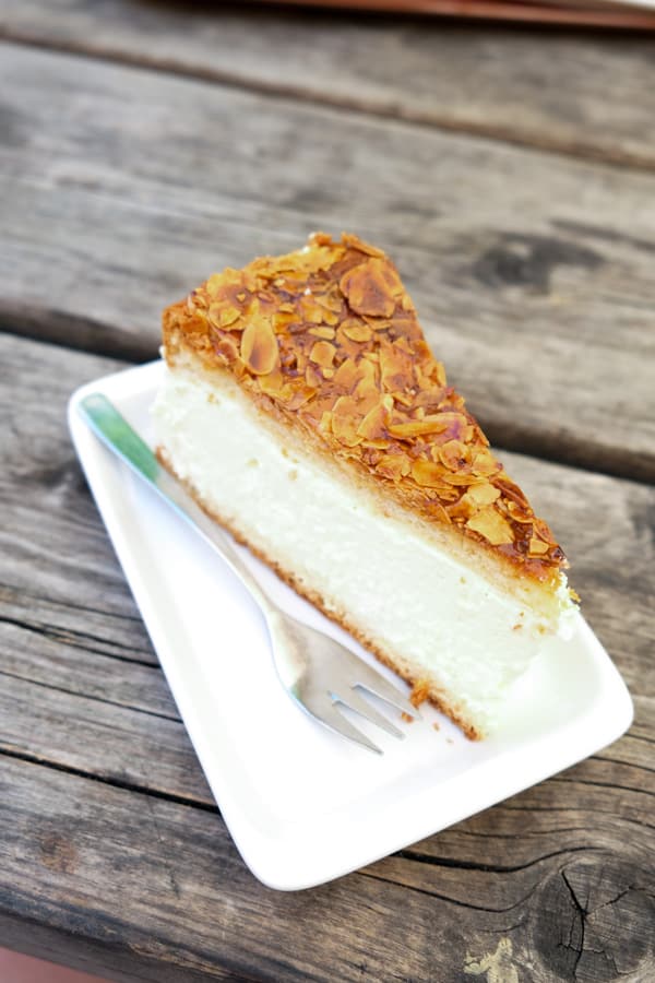 a slice of German bee sting cake on a white plate with fork